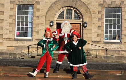 Santa and two elves outside of Ushaw