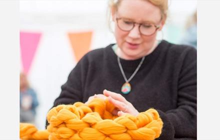A woman demonstrating finger crochet