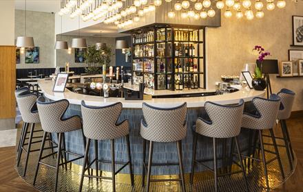 Jozef’s Riverside Bar & Restaurant - seating around a stylish bar with soft lighting above.
