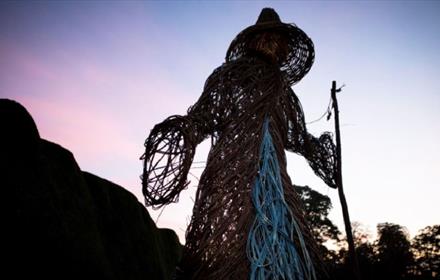 wicker Halloween witch. Trees in background.