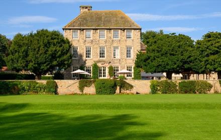 Headlam Hall Hotel in the distance. Looking at it from the gardens and a large green lawn.