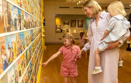 A woman and her two children looking at the Ladybird Exhibition at Ushaw.
