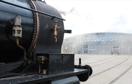 Train in front of the collection building at Locomotion