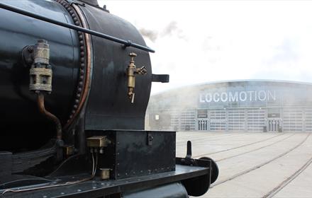 Steam train in front of the collections building at Locomotion