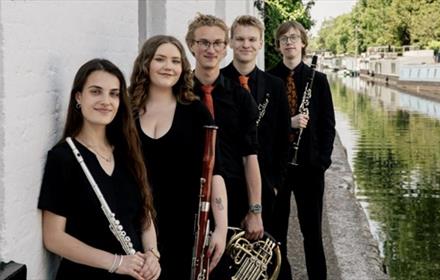 The five members of Lumas Winds holding musical instruments