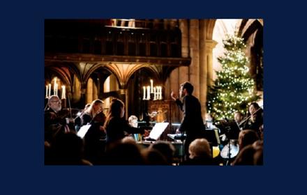 Northern Sinfonia performing inside Durham Cathedral. Christmas tree with white lights.