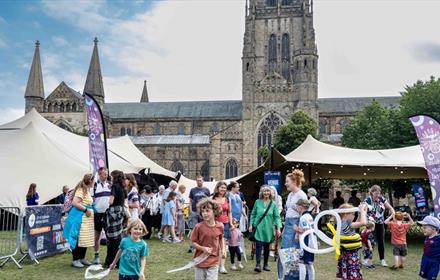 Crowds of people enjoying the Durham Fringe Festival on Palace Green, Durham City.