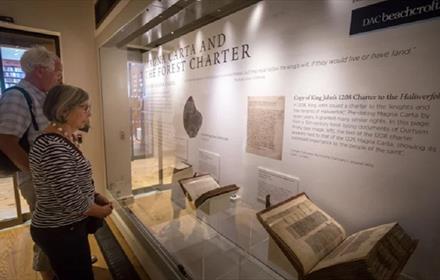 Two visitors to the Cathedral Museum looking at the Magna Carta display from 2017