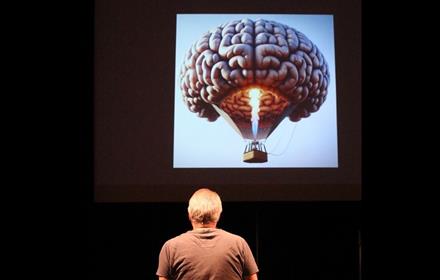 man looking at a hot air balloon in the shape of a brain