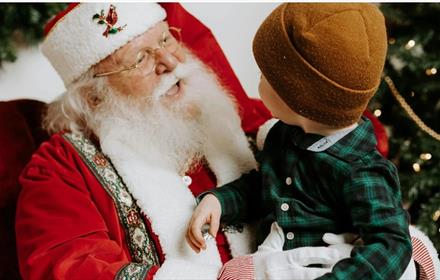 A small child sitting on Santa's knee
