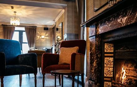 Cosy fireplace surrounded by chairs.