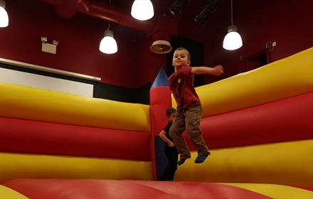 A child enjoying playing on a bouncy castle