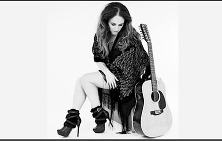 Black and white photo of Sandi Thom with her guitar.