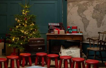 Christmas Tree, writing desk, presents and red stools.