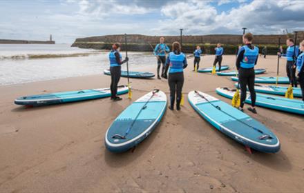 Adults preparing for a SUP lesson at Seaham Harbour Marina