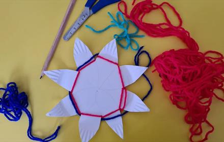 Craft materials for weaving your own woollen flower.