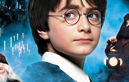 Harry Potter, Hagrid, Dumbledore and Hogwarts in the background of 'The Philosopher's Stone' movie poster.