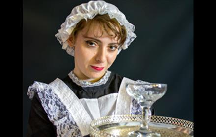 A maid serving a drink.