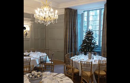 Dining tables at The Manor House Hotel, with festive decorations and a Christmas tree.