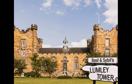 Lumley Castle Exterior and a sign which reads, 'Basil & Sybil's Lumley Towers'