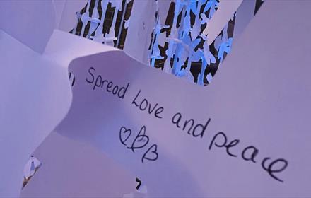 Text reads, 'Spread Love and Peace' -paper peace doves in the background.