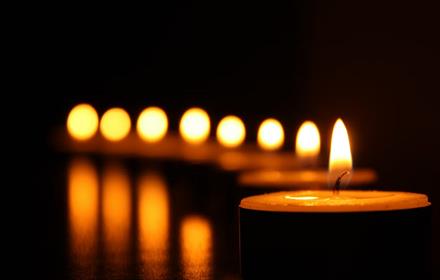 A row of candles lighting the dark.
