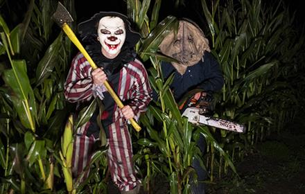 An axe wielding clown and person with a mask and chainsaw - Scare Night at Thorpe Farm Centre.
