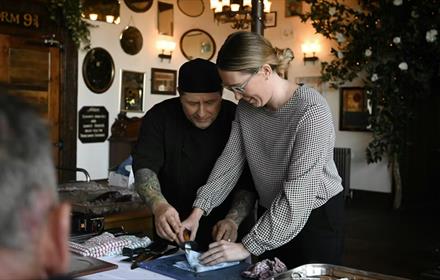 Peter Miskin showing a guest how to prepare seafood.
