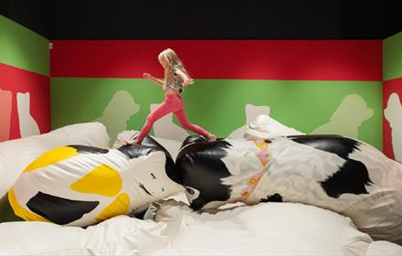 Girl running over larger-than-life, soft recreations of animal figurines - Pippa Hale Pet Project