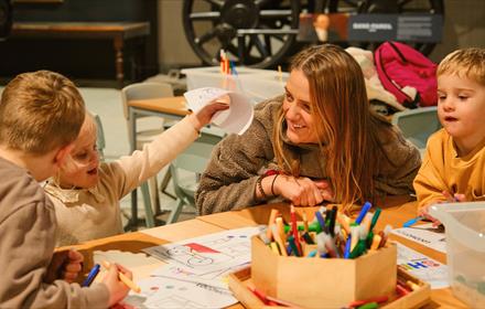 Adults and children enjoying craft activities at Locomotion.