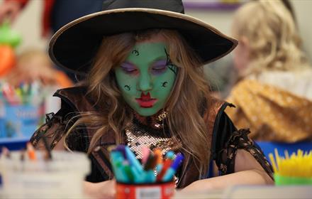 A little girl  wearing a handcrafted witch's hat. Hopetown Darlington.