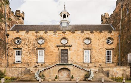 An entrance to Lumley Castle, two floral staircases leading to a door.