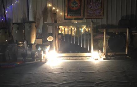 Drums in a steel barn decorated with fairy lights and cushions