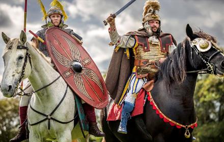Two Roman soldiers riding horses into battle