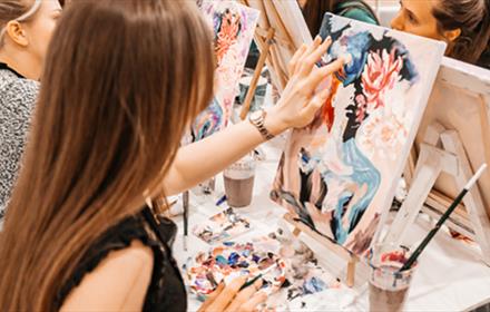 Artists painting colourful portraits.