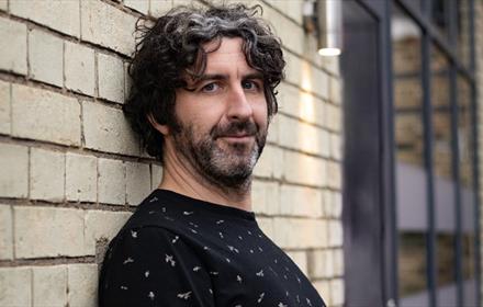Mark Watson leaning against a wall