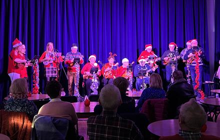 D'Ukes of Scarth performing at Christmas in Santa hats.