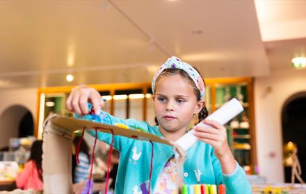 A child partaking in arts and crafts at The Bowes Museum