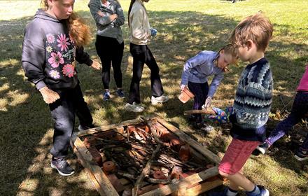 A group of children building habitats for hedgehogs.