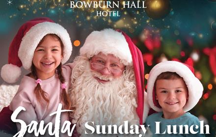 Santa and two children wearing Santa hats at Bowburn Hall Hotel.