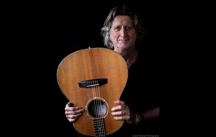 Steve Knightley holding a guitar upside down