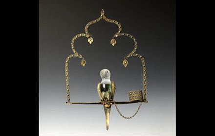 Crystal bird sitting on a perch.