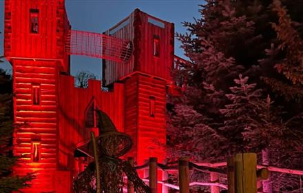 Image of a wicker witch in The Plotters' Forest illuminated in spooky red lighting.