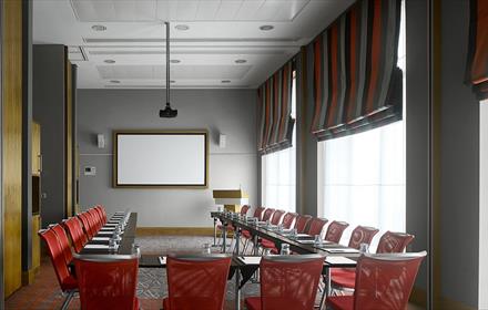 Meeting room with chairs, large table and screen