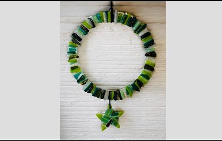 A wreath make from fused glass, various colours of green.