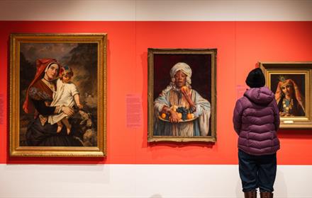 A visitor admiring portraits at The Bowes Museum from the Joséphine Bowes Trendsetters and Trailblazers exhibition