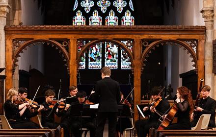 Durham student orchestra performing in St Oswald's Church, Durham City.