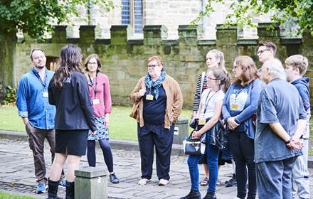 A group of people on a guided tour of Durham World Heritage Site