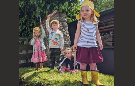 4 young children with craft Roman helmets and swords that they have made