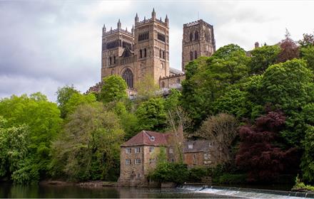 view of the west and central towers of Durham Cathedral with trees, Fulling Mill and River Wear in the foreground